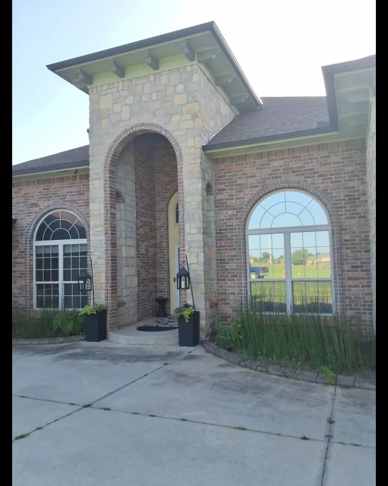 Before: Edmond home's stone entry arch surrounded by red-orange brick and pale green trim